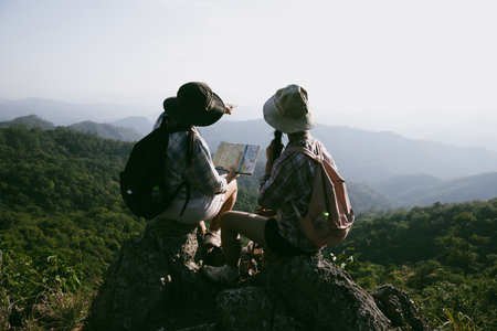 Woman hiker on top of mountain. Hiker with arms up on top of mountain successful young woman enjoying triumph. traveler exploring world. Hikers with backpacks relaxing. Sport and success concept.の写真素材