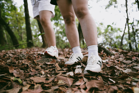 Hiking action on mountain grass trail path. Close up of female hiker shoe. adventurous lifestyle of hiker and backpack to travel and trek mountain, enjoy every walk and hike part of thrilling journeyの写真素材