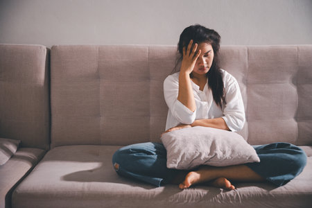 Sorrowful woman sat alone, overwhelmed by emotion, her sad and unhappy expression revealing deep despair, stress and distress left feeling depressed. sorrowful sad, despair alone, depressed stressの写真素材