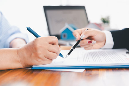 Bank approve loan to buy home concept. Real estate agent talked about terms of home purchase agreement, asked customer to sign documents to make contract legally. approved mortgage application form.の写真素材