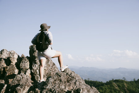 Woman hiker on top of mountain. Hiker with arms up on top of mountain successful young woman enjoying triumph. traveler exploring world. Hikers with backpacks relaxing. Sport and success concept.の写真素材