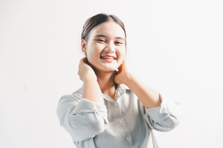 Asian woman rejoicing, looking happy, champion, fist pump gesture, standing over white background. young woman had happy, positive expression on her face, highlighted by bright smile.の写真素材