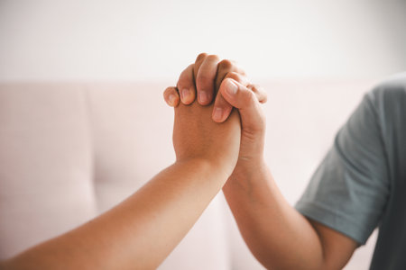 Hope and trust with crisis concept. Closeup, love and holding hands for support, comfort and care with grief, loss and empathy. people and family with compassion, sympathy and healing with bonding.の写真素材