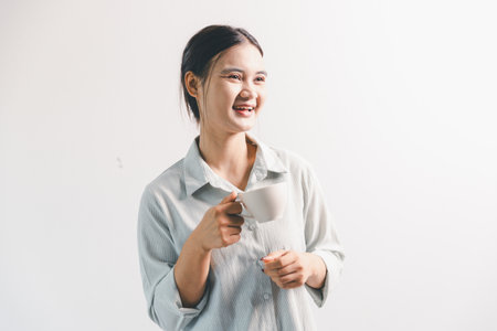 Asian woman rejoicing, looking happy, champion, fist pump gesture, standing over white background....