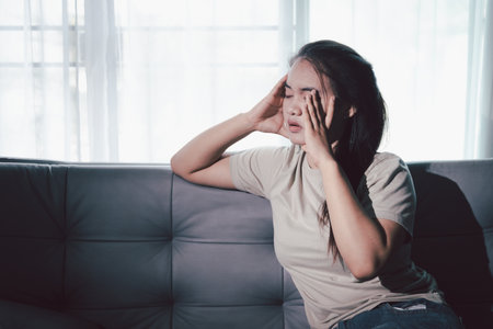Sorrowful woman sat alone, overwhelmed by emotion, her sad and unhappy expression revealing deep despair, stress and distress left feeling depressed. sorrowful sad, despair alone, depressed stressの写真素材