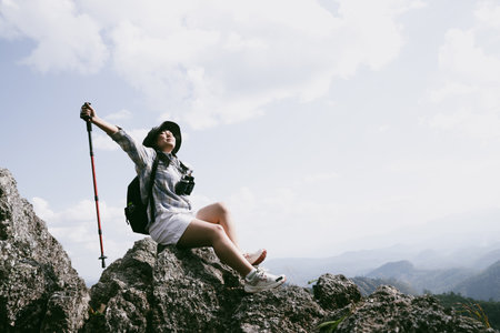 Woman hiker on top of mountain. Hiker with arms up on top of mountain successful young woman enjoying triumph. traveler exploring world. Hikers with backpacks relaxing. Sport and success concept.の写真素材
