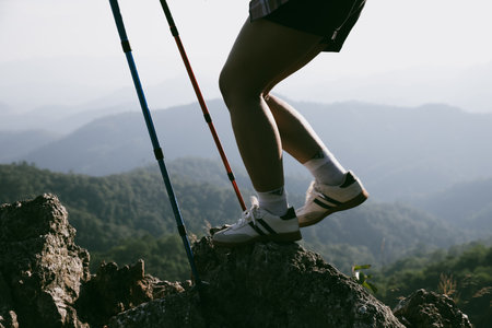 Hiking boot. Close up of female legs in boots on hiking trail on top of mountain outdoor. young woman reaching top of mountain. women feet wearing hiking boots on rock. Travel, vacation concept.の写真素材