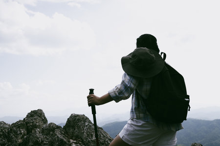 Woman hiker on top of mountain. Hiker with arms up on top of mountain successful young woman enjoying triumph. traveler exploring world. Hikers with backpacks relaxing. Sport and success concept.の写真素材