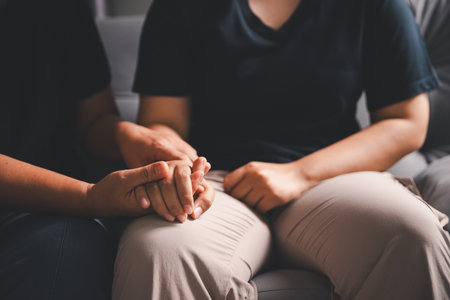 Hope and trust with crisis concept. Closeup, love and holding hands for support, comfort and care with grief, loss and empathy. people and family with compassion, sympathy and healing with bonding.の写真素材