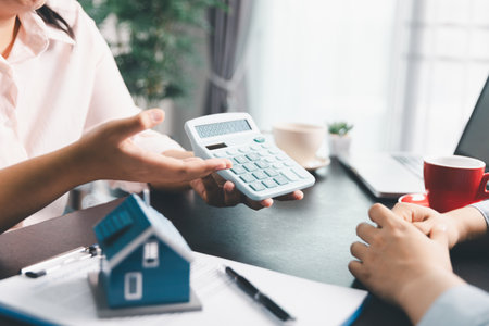 Woman real estate sale agent, client after signing agreement contract real estate with approved mortgage application form concerning mortgage loan offer, house insurance. contract agreement in officeの写真素材