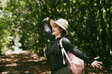 Young female traveler with backpack walking in national park or forest. recreation sport in nature....