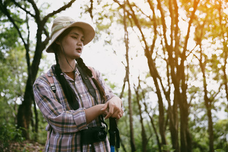 Young female traveler with backpack walking in national park or forest. recreation sport in nature. Female person bag, wave for hiking journey in woods. adventure in forest. trekking with backpackの写真素材