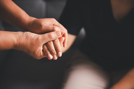 Hope and trust with crisis concept. Closeup, love and holding hands for support, comfort and care with grief, loss and empathy. people and family with compassion, sympathy and healing with bonding.の写真素材