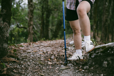Hiking action on mountain grass trail path. Close up of female hiker shoe. adventurous lifestyle of hiker and backpack to travel and trek mountain, enjoy every walk and hike part of thrilling journeyの写真素材