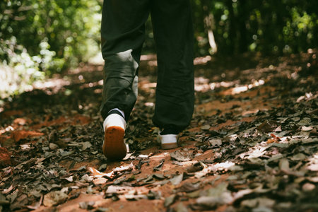 Hiking action on mountain grass trail path. Close up of female hiker shoe. adventurous lifestyle of hiker and backpack to travel and trek mountain, enjoy every walk and hike part of thrilling journeyの写真素材