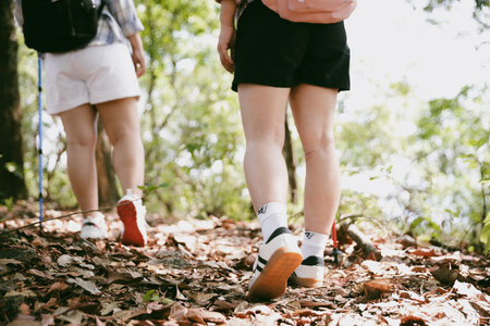 Hiking action on mountain grass trail path. Close up of female hiker shoe. adventurous lifestyle of hiker and backpack to travel and trek mountain, enjoy every walk and hike part of thrilling journeyの写真素材