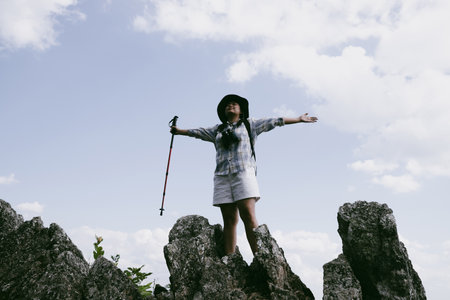 Woman hiker on top of mountain. Hiker with arms up on top of mountain successful young woman enjoying triumph. traveler exploring world. Hikers with backpacks relaxing. Sport and success concept.の写真素材