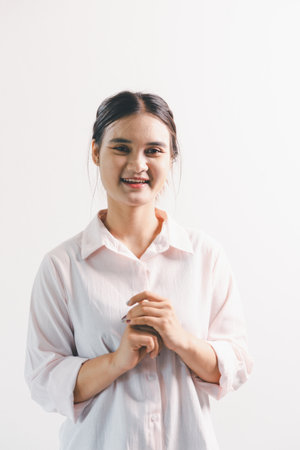 Asian woman rejoicing, looking happy, champion, fist pump gesture, standing over white background. young woman had happy, positive expression on her face, highlighted by bright smile.の写真素材