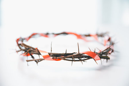 Crown of thorns on white table background. Easter, central celebration in Christianity, honors sacrifice of Jesus Christ, crown of thorns symbolizes redemption, faith, deep spirituality of religion.の写真素材
