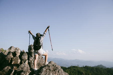 Woman hiker on top of mountain. Hiker with arms up on top of mountain successful young woman enjoying triumph. traveler exploring world. Hikers with backpacks relaxing. Sport and success concept.の写真素材