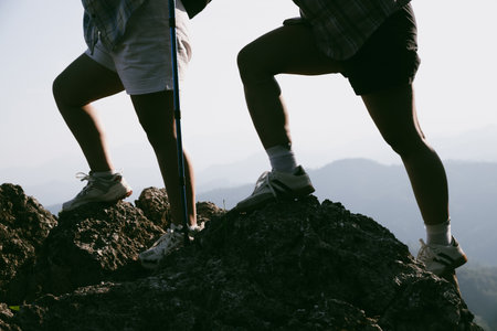 Hiking boot. Close up of female legs in boots on hiking trail on top of mountain outdoor. young woman reaching top of mountain. women feet wearing hiking boots on rock. Travel, vacation concept.の写真素材