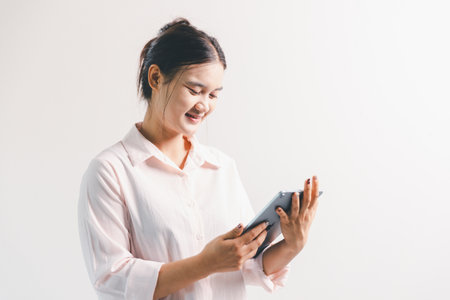 Asian woman rejoicing, looking happy, champion, fist pump gesture, standing over white background....