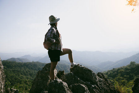 Woman hiker on top of mountain. Hiker with arms up on top of mountain successful young woman enjoying triumph. traveler exploring world. Hikers with backpacks relaxing. Sport and success concept.の写真素材