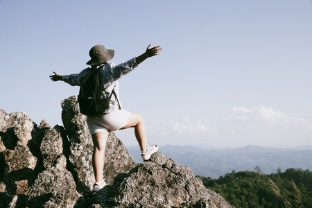 Woman hiker on top of mountain. Hiker with arms up on top of mountain successful young woman enjoying triumph. traveler exploring world. Hikers with backpacks relaxing. Sport and success concept.の写真素材