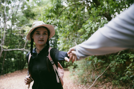 Two friends helping with teamwork trying to reach top of mountains during wonderful summer sunset. Teamwork couple hiking help each other trust assistance. Team of climbers two friends hiker.の写真素材
