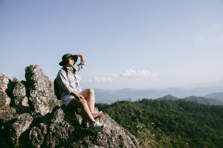 Woman hiker on top of mountain. Hiker with arms up on top of mountain successful young woman enjoying triumph. traveler exploring world. Hikers with backpacks relaxing. Sport and success concept.の写真素材