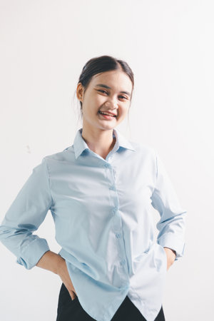 Asian woman rejoicing, looking happy, champion, fist pump gesture, standing over white background. young woman had happy, positive expression on her face, highlighted by bright smile.の写真素材