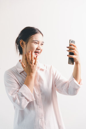 Asian woman rejoicing, looking happy, champion, fist pump gesture, standing over white background. young woman had happy, positive expression on her face, highlighted by bright smile.の写真素材