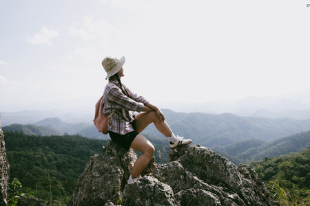 Woman hiker on top of mountain. Hiker with arms up on top of mountain successful young woman enjoying triumph. traveler exploring world. Hikers with backpacks relaxing. Sport and success concept.の写真素材