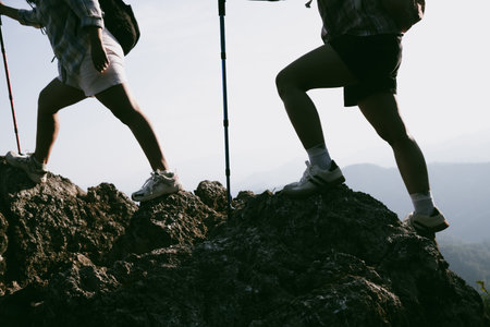 Hiking boot. Close up of female legs in boots on hiking trail on top of mountain outdoor. young woman reaching top of mountain. women feet wearing hiking boots on rock. Travel, vacation concept.の写真素材