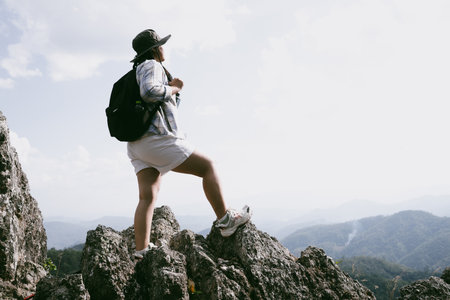 Woman hiker on top of mountain. Hiker with arms up on top of mountain successful young woman enjoying triumph. traveler exploring world. Hikers with backpacks relaxing. Sport and success concept.の写真素材
