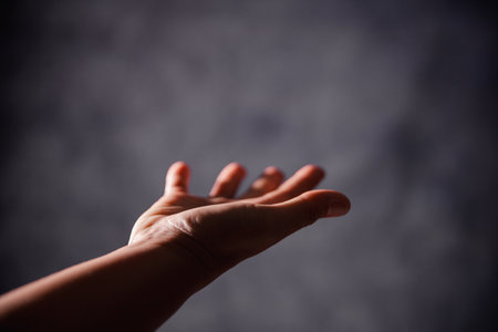 Christian woman lifts her hand in worship to pray, hope, faith, and deep belief in God defines core concept of religion. Praying hands with faith in religion, belief in God. Power of hope or love.の写真素材