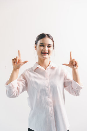 Asian woman rejoicing, looking happy, champion, fist pump gesture, standing over white background....