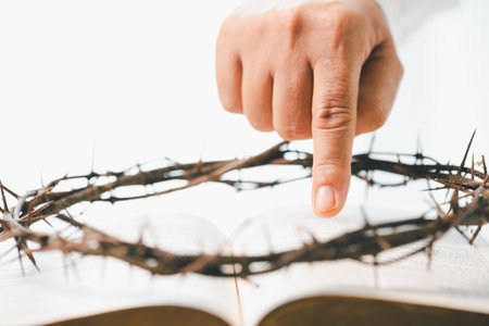 Crown of cross with hand. Crown of thorns on head and hands nailed to cross, Jesus Christ made ultimate sacrifice, symbolizing faith, belief and profound religious and spiritual meaning of Easter.の写真素材