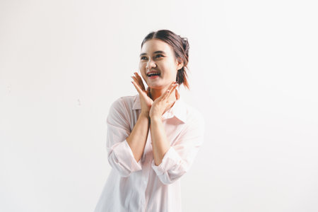 Asian woman looking happy, standing over white background. young woman had happy, positive...