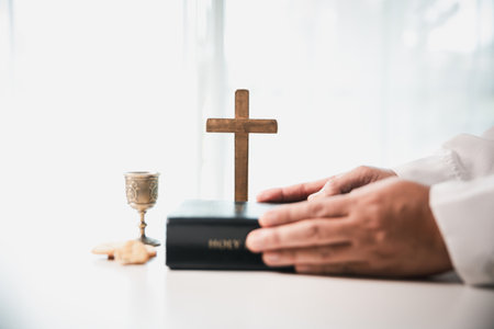During the holy communion ceremony in church, a hand is extended in faith to receive the sacred sacrament, reflecting the spiritual and religious worship central to Christianity.の写真素材