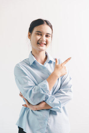 Asian woman looking happy, standing over white background. young woman had happy, positive expression on her face, highlighted by bright smile.の写真素材