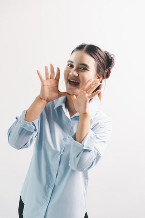 Asian woman rejoicing, looking happy, fist pump gesture, standing over white background. young woman...