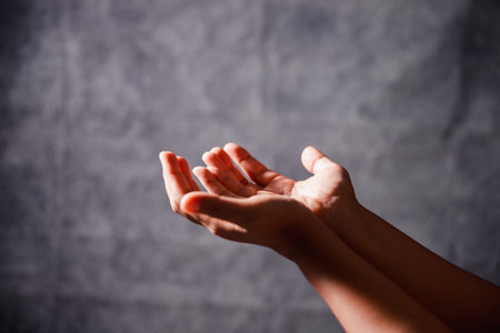 Christian woman lifts her hand in worship to pray, hope, faith, and deep belief in God defines core...