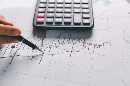 Auditor reviews financial statement and balance sheet on desk using a calculator, representing the concept of accounting, audit, and finance in preparing a detailed financial report for the business.の写真素材