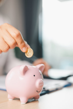 Hand holding coin symbolizes saving, investment, smart finance decisions money, currency, cash financial wealth, driving business growth, economic stability, long-term success in banking economy.の写真素材