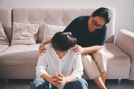 Moment of deep grief, sorrow and anxiety, lonely person overwhelmed by despair feels spark of hope when helping hand reaches out with genuine emotion to ease their problem.の写真素材