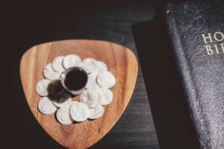 Holy communion bread and wine cup placed on the Holy Bible, symbolizing the Lord Supper, Eucharist,...