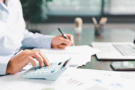 Businesswoman manages finances by using banking and accounting system to calculate costs, taxes,...