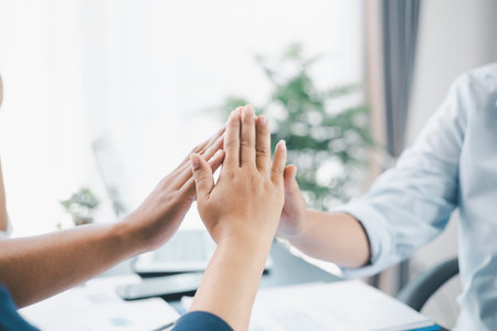 Business teamwork concept with three colleagues doing raise palms together in office, symbol of...