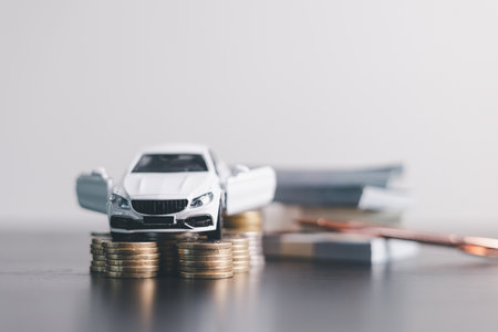 White car model with open door surrounded by stacked coins, symbolizing auto loan, car finance, investment, insurance, and savings concept on a clean minimal background. car financeの写真素材